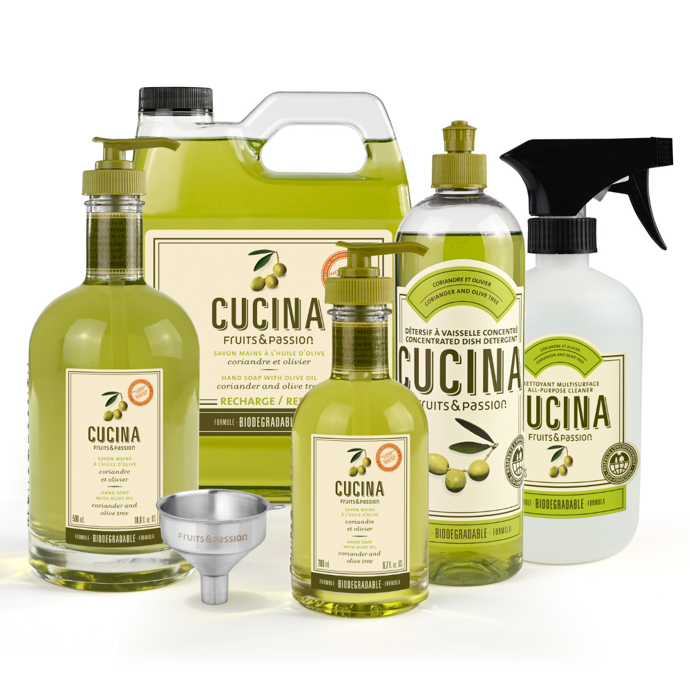 A set of Cucina Fruits & Passion olive oil products on a white background, including a large jug, a bottle, a spray bottle, a smaller bottle, a metal funnel, and a label.
