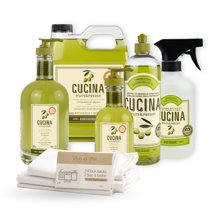 A kitchen and cleaning product set on a white background, including olive oil bottles, a spray bottle, folded white towels, and a packaged pack of flour sacks. The products feature green, yellow, and beige packaging with the brand name CUCINA and sub-brand Vive la Vie.